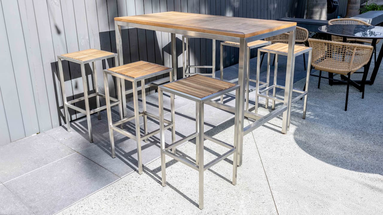 Stainless steel outdoor bar leaner and stools at LAT Bar